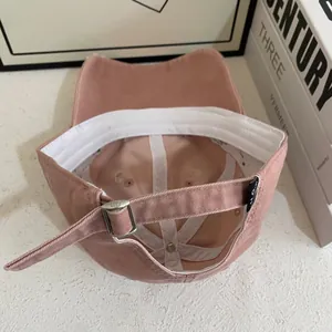 Detail of pink cotton baseball cap interior showing white sweatband and adjustable metal strap