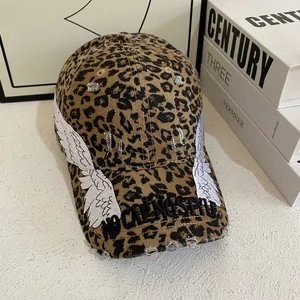 Close-up of leopard baseball cap with wing embroidery and distressed ripped details