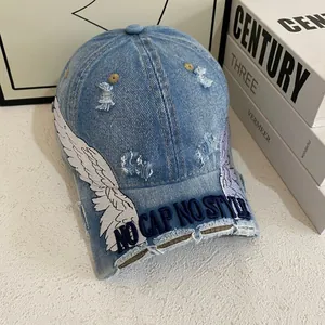 Distressed blue denim baseball cap with white wing embroidery and No Cap No Style text