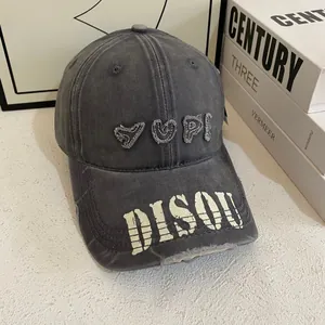 Detail of washed grey baseball cap featuring YUPI embroidery and DISQU letter print