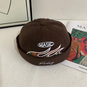 Detalle de gorro docker marrón oscuro con bordado MASIC y patrones ondulados de colores