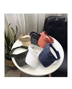 Close-up of six assorted washed cotton canvas visor hats on a table showing visor stitching