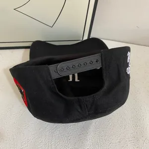Detail view of the black baseball cap with adjustable snapback and side embroidery