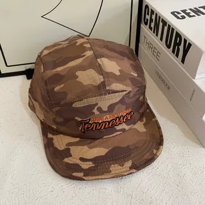 Détail de la casquette cinq panneaux camouflage avec broderie orange et tissu ripstop