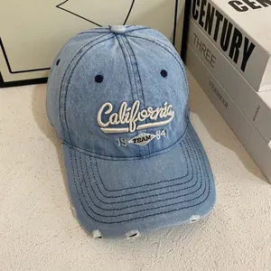 Detailed close-up of California 1984 embroidery and distressed edges on denim baseball cap