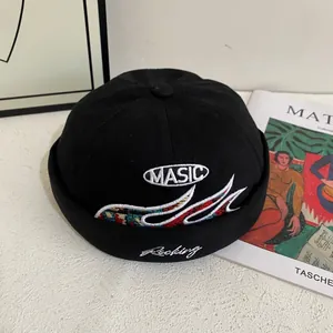 Detalle del gorro docker de lona negra con intrincado bordado MASIC y diseño de ondas