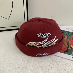 Gorro docker burdeos con bordado MASIC y texto Rocking en un escritorio blanco texturizado