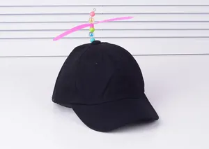 Close-up of black cotton baseball cap with a colorful spinning propeller on top