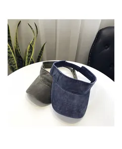 Detail of army green and navy blue washed cotton sun visors on a white table