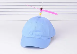 Close-up of light blue kids baseball cap featuring a pink propeller and colorful bead decoration