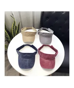 Detail of four colorful washed canvas sun visors with parallel stitching and adjustable straps