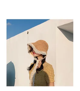Close-up of woven straw hat featuring elegant white lace edges and long decorative ties