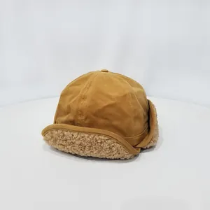 Detalle del gorro aviador amarillo con forro de lana de cordero beige y tela suave