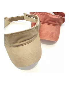 Detail view of khaki and red cotton sun visors showing stitching and 100% cotton label