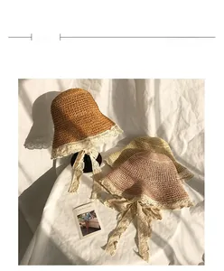 Close-up of woven straw sun hats in brown, beige and pink with delicate lace trim detailing