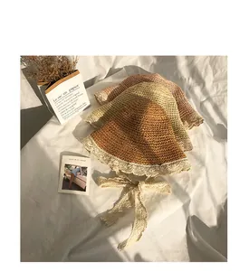 Close-up of woven straw hats with white lace edges and ties in multiple summer colors