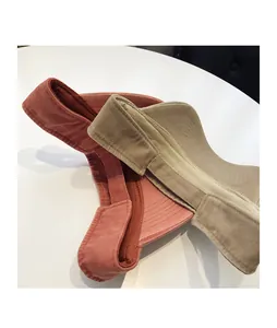 Detail of pink and beige corduroy sun visors showing premium ribbed texture and wide brim