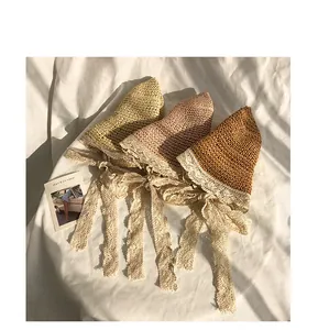 Three hand-woven straw sun hats in yellow, pink, and brown with delicate lace straps