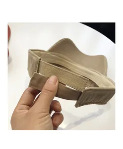 Detail showing the adjustable Velcro strap on the khaki sun hat for a custom fit