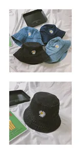 Detailed view of daisy embroidery on denim bucket hats in multiple vintage blue washes