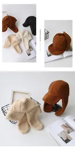 Close-up of thick sherpa fleece earflap hats in caramel, black, and cream colors