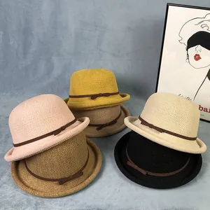 Dettagli di cappelli di paglia intrecciati in cinque colori con sottili fiocchi marroni