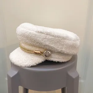 Detail of white sherpa newsboy cap with gold braided rope and vintage metal button