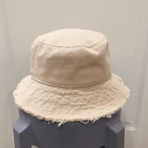Gros plan détaillé d'un chapeau bob en toile de coton beige avec bords effilochés