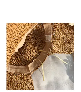 Detail of woven straw sun hat interior with sweatband and 100% paper material label
