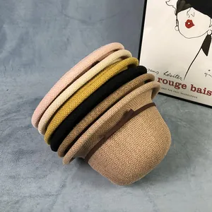 Dettaglio di cappelli di paglia intrecciati colorati con eleganti nastri marroni