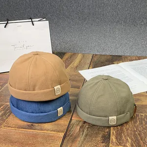 Bonnets Docker classiques en kaki, bleu marine et vert foncé sur table en bois