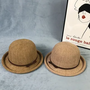Dettaglio di due cappelli di paglia intrecciati con fiocco su sfondo blu