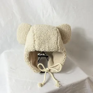 Creamy white plush winter hat with cute bear ears and straps on a display stand