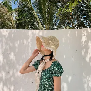 Women's woven straw sun hat with white lace trim and ties for beach travel