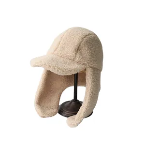 Plush beige faux shearling baseball hat with earflaps for winter warmth shown on stand