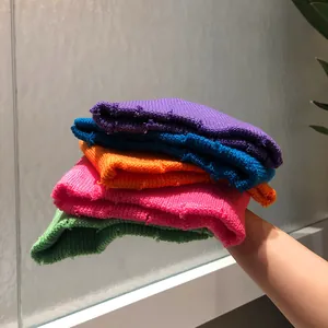 Detalle de gorros de punto en cinco colores vibrantes con textura de agujeros moderna