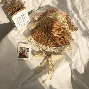 Foldable woven straw sun hat with lace trim and ribbon in brown, beige, and pink colors