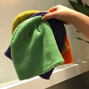 Detalle de gorros de punto coloridos con textura suave y diseño de agujeros desgastados
