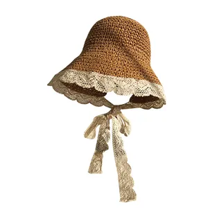 Caramel straw sun hat with wide lace trim and decorative ties for summer beach wear