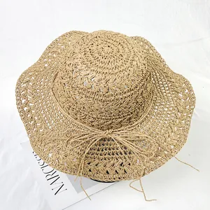 Detail of hand-woven straw sun hat showing intricate texture and decorative bow tie