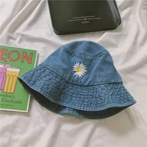 Blue denim bucket hat with daisy embroidery and a minimalist street style design