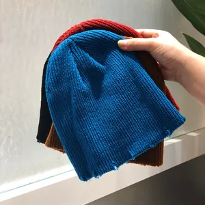 Detalle de los bordes desgastados y la textura de punto en gorros de varios colores