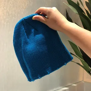 Primer plano detallado del diseño rasgado en el gorro de punto acanalado azul vivo