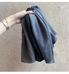 Texture gaufrée détaillée des bonnets en tricot gris foncé, noir et bleu-violet