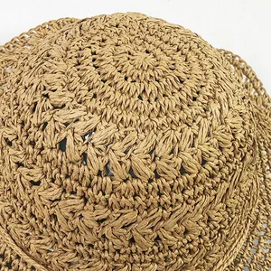 Macro shot of natural hand-woven straw hat showing spiral crochet texture and craftsmanship