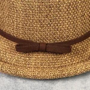 Dettaglio ravvicinato di cappello di paglia intrecciata kaki con nastro marrone