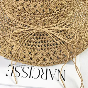 Detailed close-up of handmade crochet straw hat with woven texture and bow accent