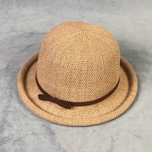 Dettaglio cappello di paglia intrecciata marrone chiaro con nastro e fiocco laterale