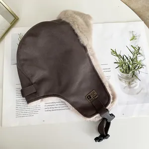 Dettaglio del cappello da aviatore in finta pelle scamosciata con fodera in peluche