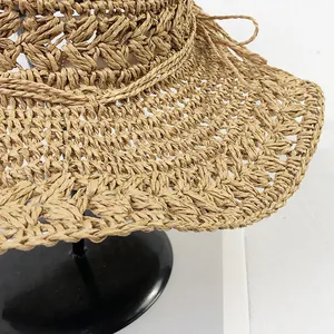 Detailed view of the intricate hand-crocheted hollow texture on the beige straw hat